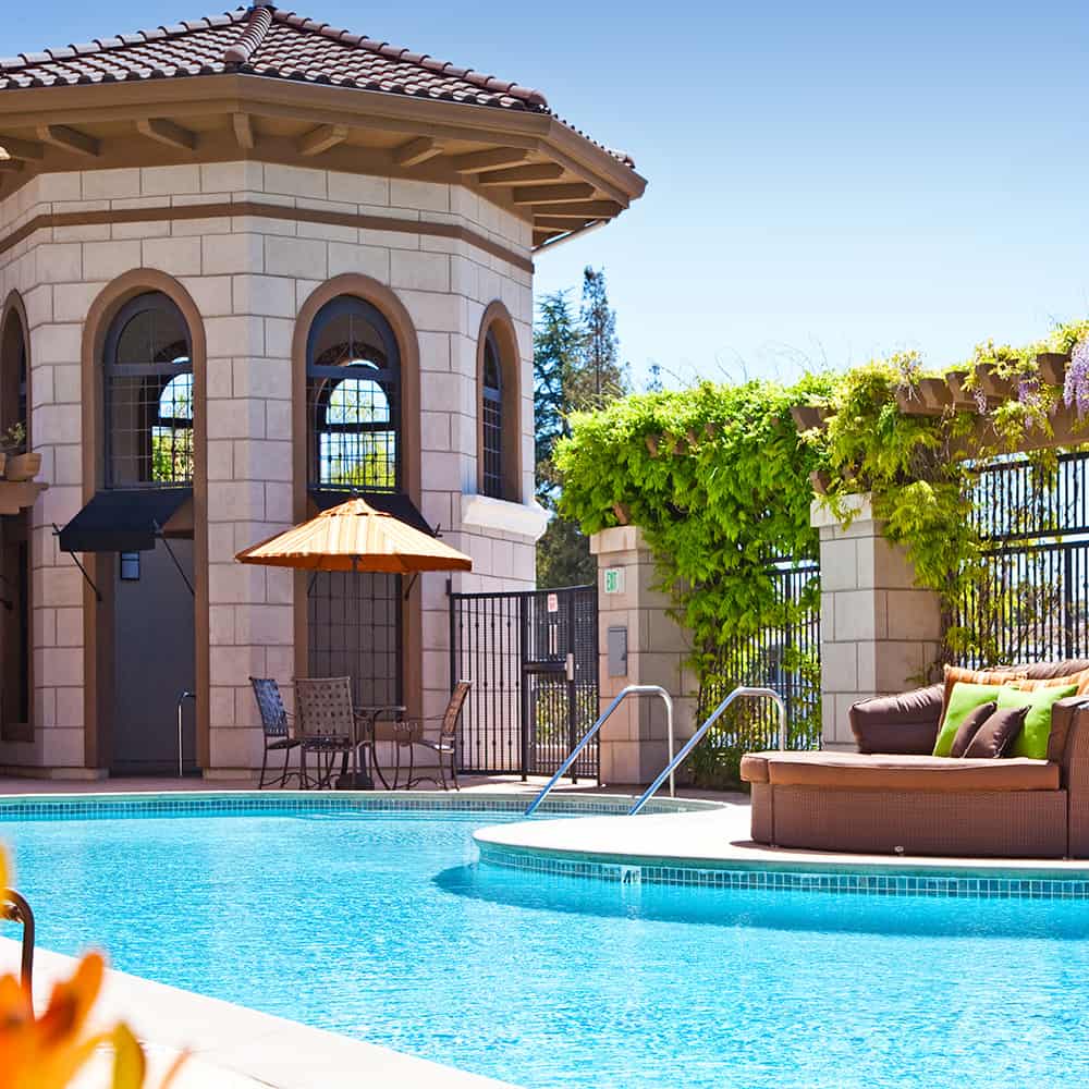 Shaded area with outdoor furniture, next to a swimming pool in a Concorde, California apartments