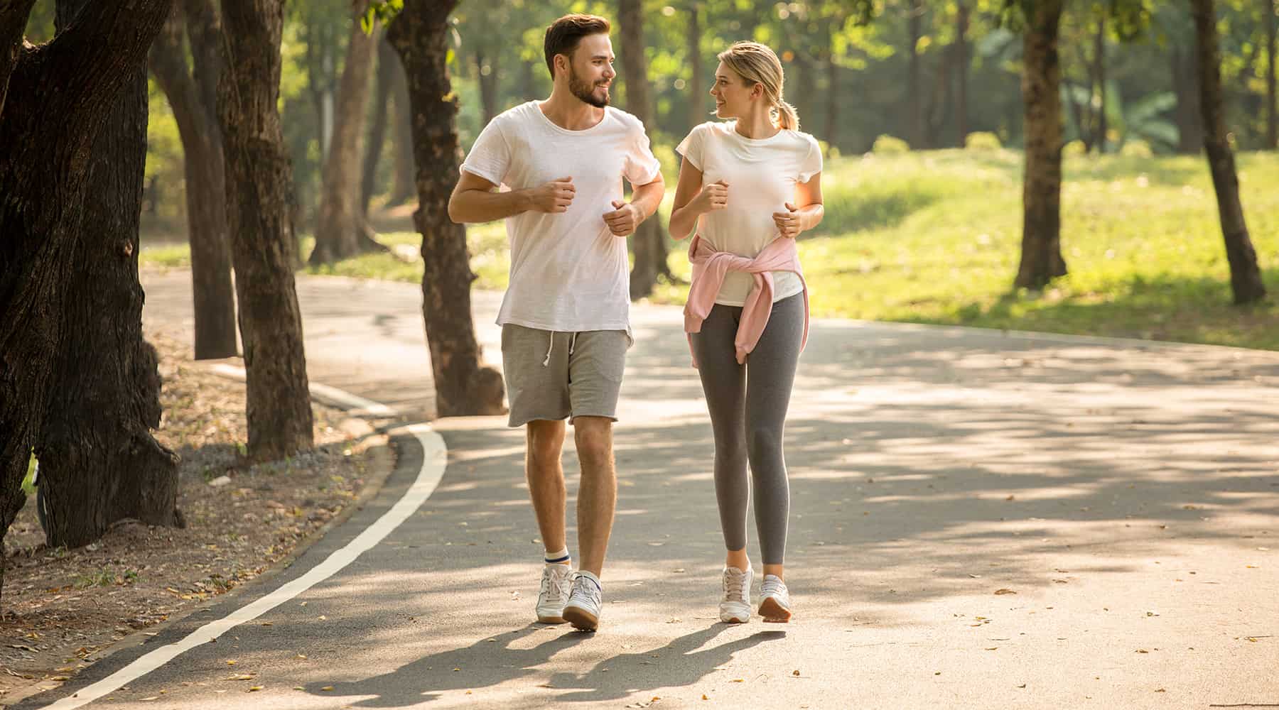 A couple wearing sports clothes, jogging at a running trail in Concorde, California.