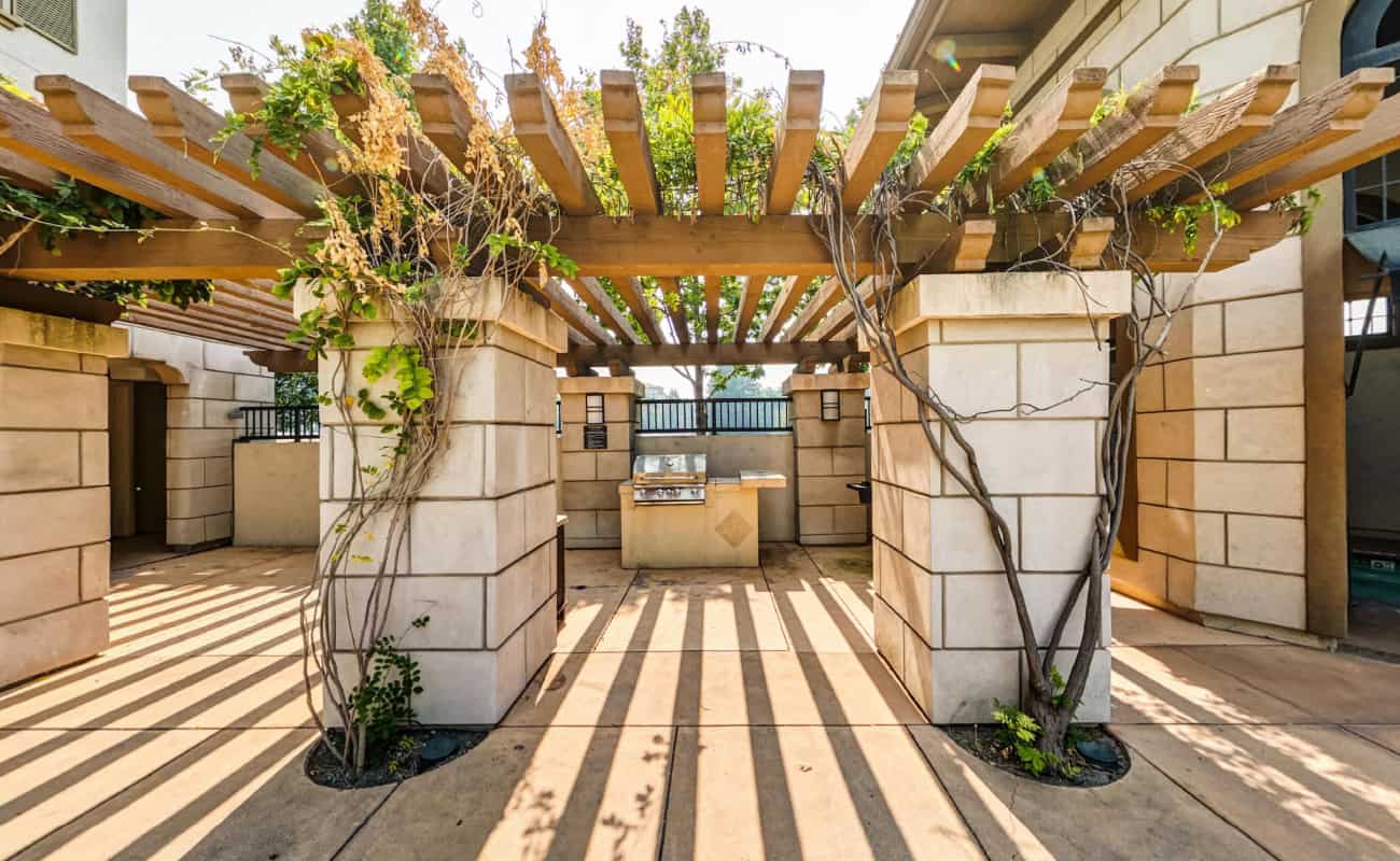 BBQ Pergola under greenery sitting out by the pool